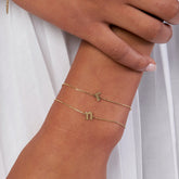 14k Yellow Gold Old English Initial Bracelet on woman's wrist